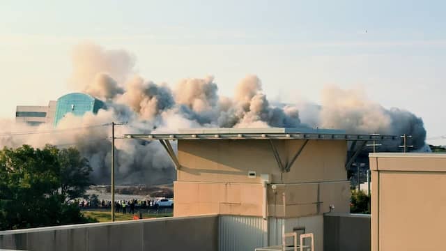 Omstander filmt rookpluimen na gecontroleerde implosie van gebouw in VS