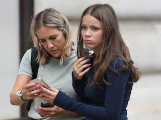 Tiener en ouder met telefoon