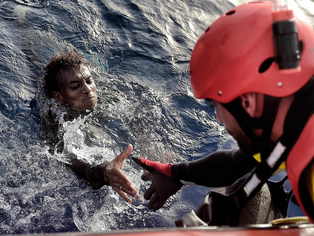 Een vluchteling wordt uit het water gehaald bij een recente reddingsoperatie.