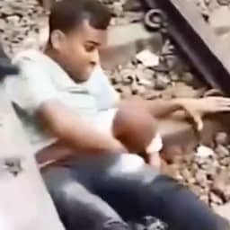 Video | Vader drukt zich plat en redt zoon terwijl trein over hen heen rijdt