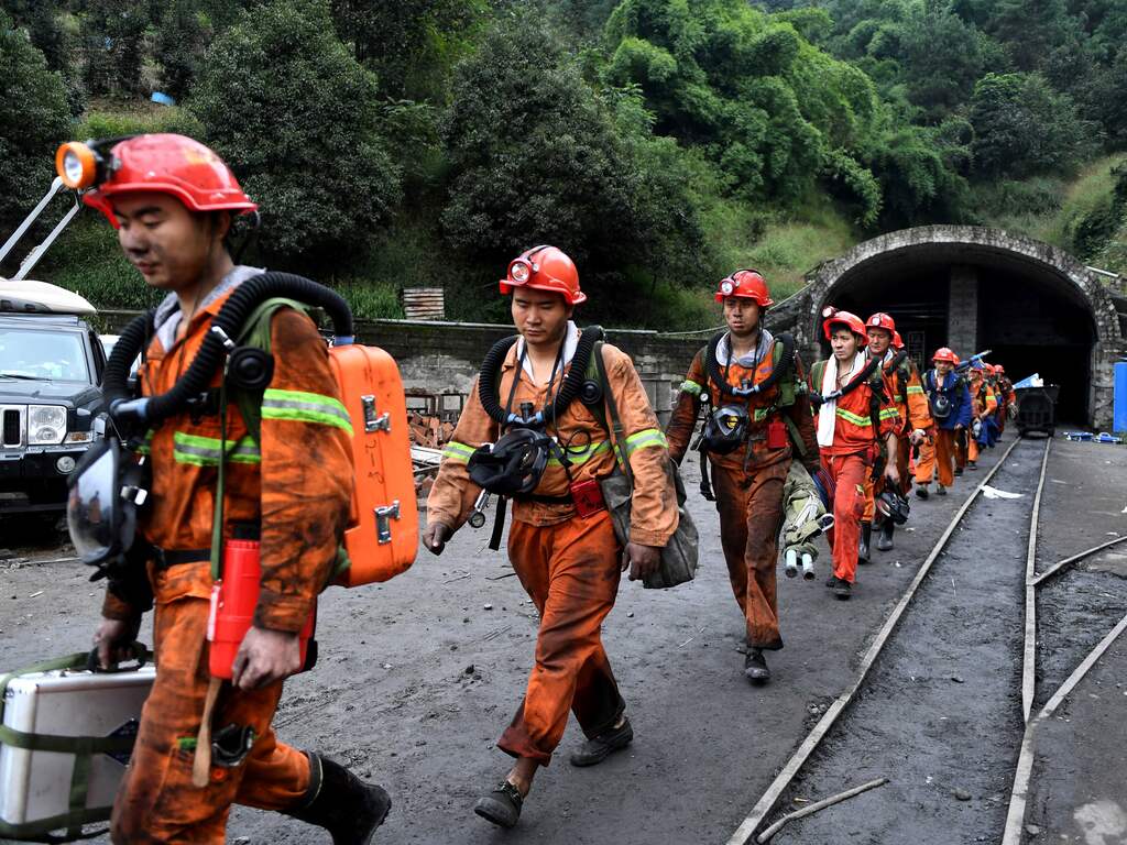 Reddingswerkers verlaten een kolenmijn in het Chinese Chongqing, waar 33 mijnwerkers omkwamen bij een explosie, 01-11-2016