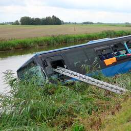 Video | Lijnbus ligt in kanaal na botsing met motorrijder in Friesland