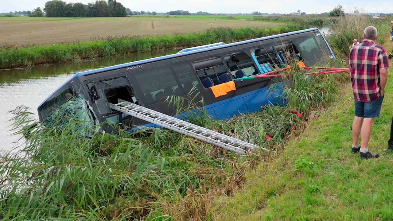 Foto bij Video | Lijnbus ligt in kanaal na botsing met motorrijder in Friesland