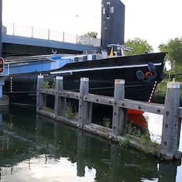 Video | Schip ligt klemvast onder brug na botsing in Weert