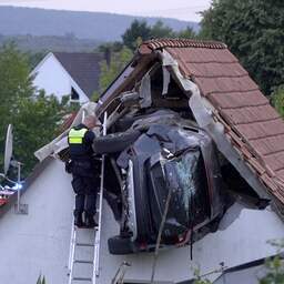 Auto raast door Duitse tuin, schept jongen op trampoline en eindigt in schuurdak