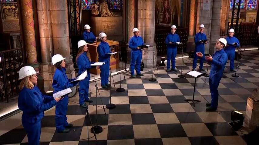 Koorzangers luiden kerst in met helmen op in Notre-Dame in Parijs