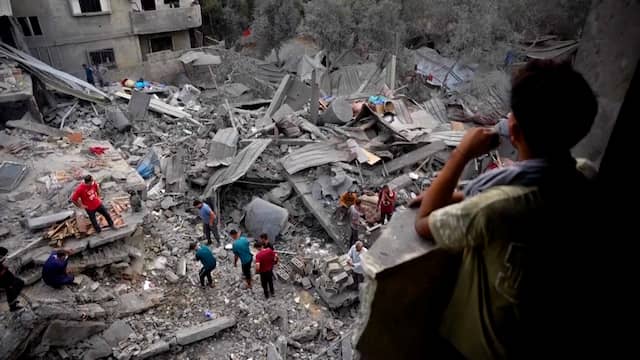 Palestijnen zoeken naar hun spullen tussen verwoeste woningen na Israëlische luchtaanval