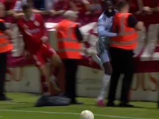 Ajax-spits Tolu krijgt duw van tegenstander en loopt steward omver