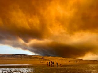 Strandbezoekers zien lucht oranje kleuren door brand in Bordeaux