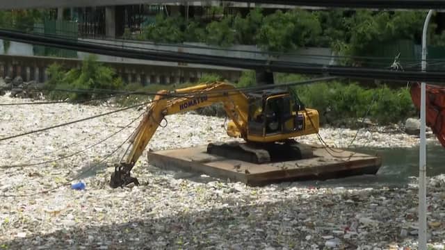 Graafmachines scheppen tonnen afval uit rivier na storm in Filipijnen