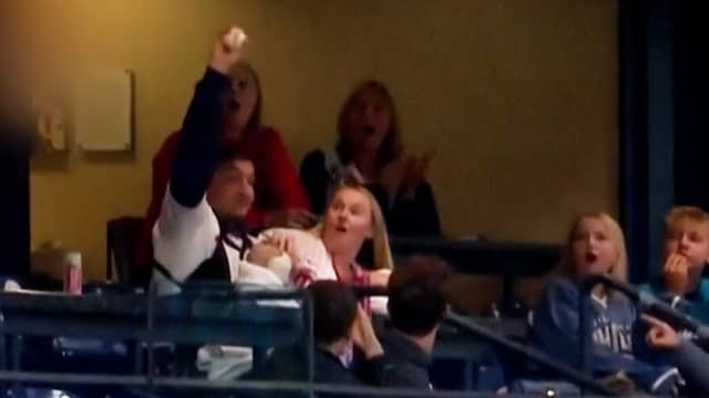 Honkbalfan vangt bal in Philadelphia terwijl hij baby vasthoudt