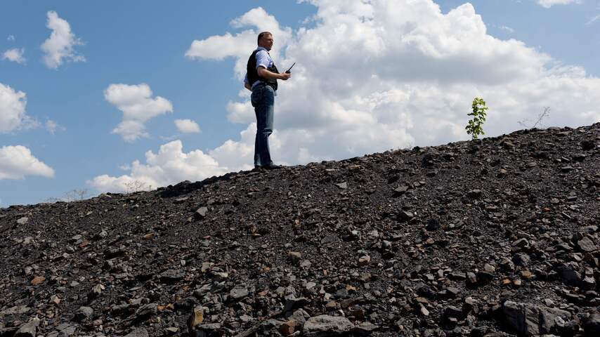 Waarnemers van de OVSE zoeken woensdag rond een kolenmijn in het rampgebied waar vlucht MH17 neerstortte naar menselijke resten.