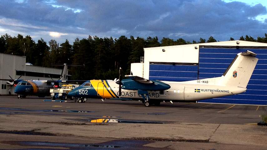 Op het vliegveld van Stockholm Skavsta staan vliegtuigen van de Zweedse Kustwacht. Boven de hangaar kwamen donderdagavond dreigende wolken aanzetten.