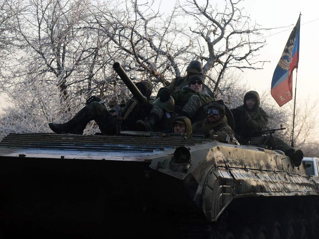 Zondag 15 februari: Pro-Russische separatisten rijden in een gevechtsvoertuig met de vlag van de zelfuitgeroepen Volksrepubliek Donetsk in de buurt van de Oekraïense stad Uglegorsk.