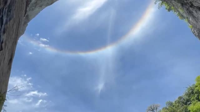 Waterval lijkt uit blauwe hemel te stromen tussen twee regenbogen