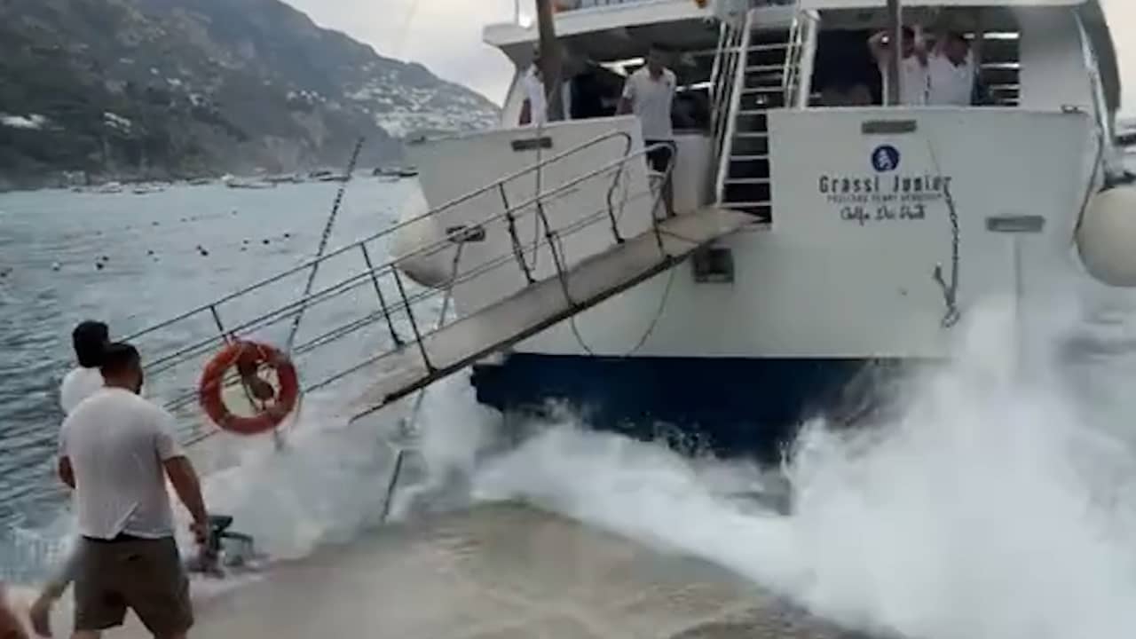 Hoge golven beuken toeristenboot tegen kade aan Amalfikust