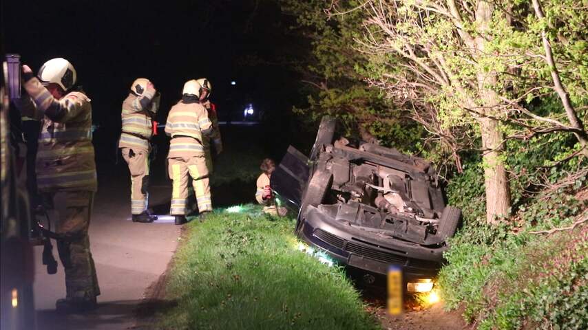 Auto van fotograaf door omstanders van brand in sloot geduwd