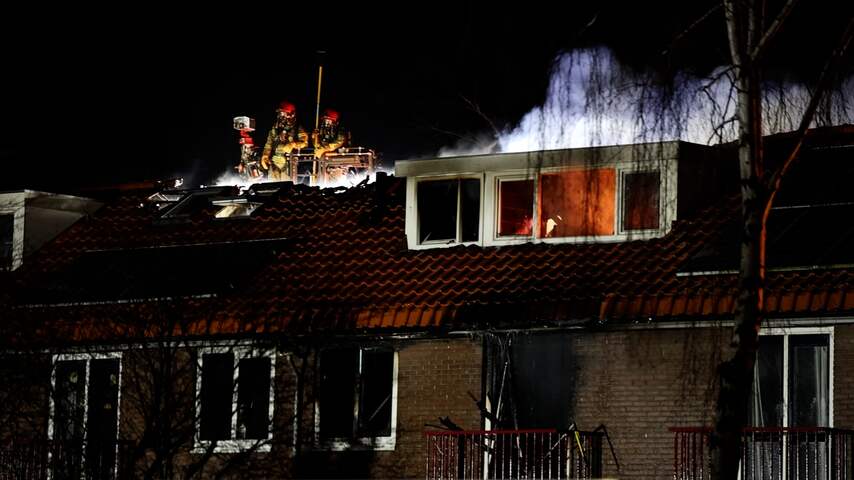 Brandweer in hoogwerker blust dak na explosie in Purmerend