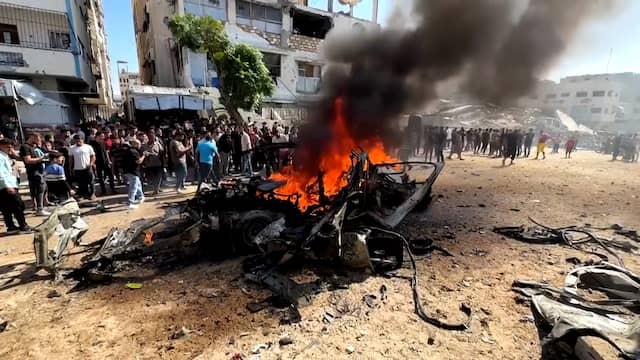 Omstanders blussen auto na Israëlische aanval op Gaza