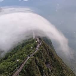 Video | Spectaculaire watervalwolk rolt over Chinese bergtoppen