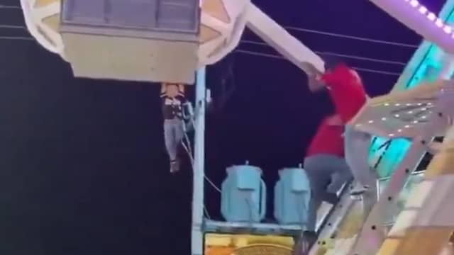 Kind hangt aan draaiend reuzenrad op kermis in Mexico