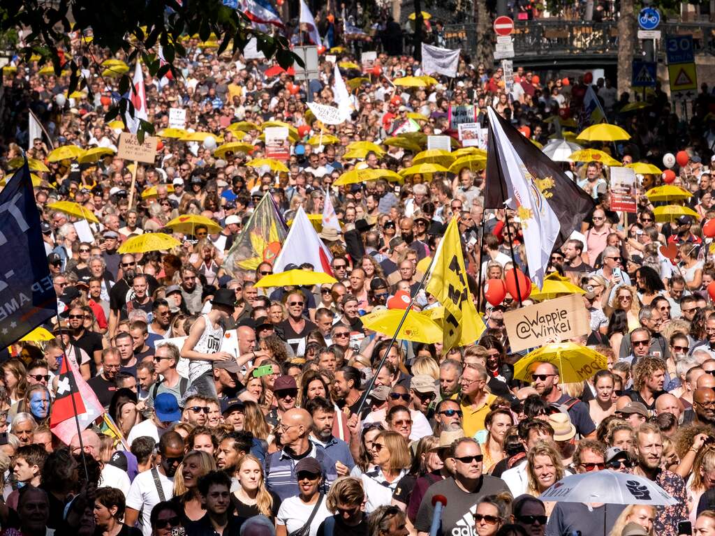 Demonstranten lopen door amsterdam tijdens de manifestatie Samen voor Nederland. De actie richt zich tegen vrijheidsbeperkende coronamaatregelen en medische apartheid.
