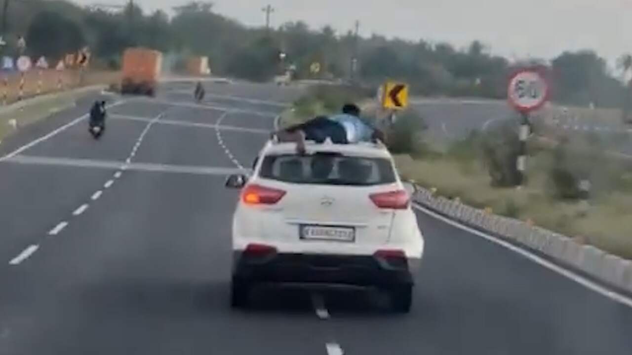 Foto bij Video | Politieagent blijft 40 kilometer hangen aan auto van smokkelaars in India