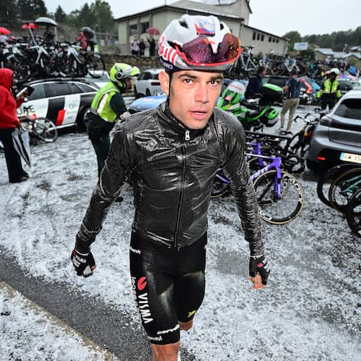 Vuelta-rit gestaakt na extreme hagelbui en stortregen: renners schuilen in café