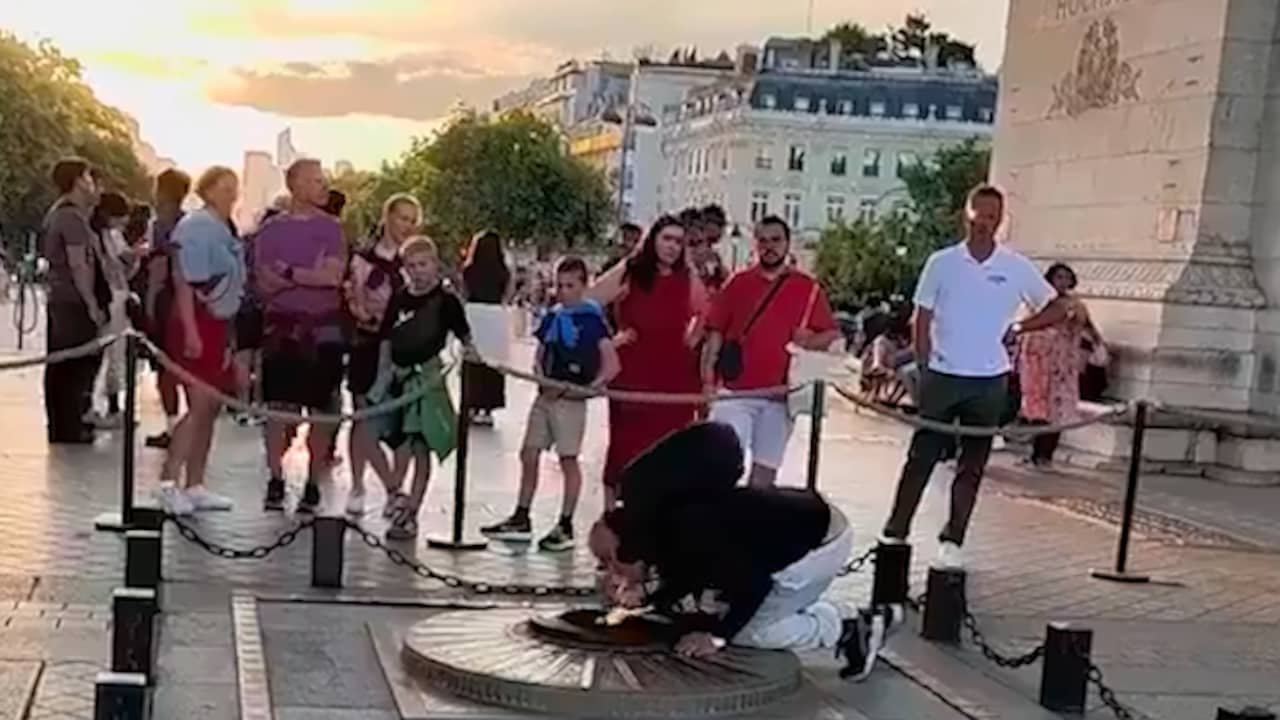 Beeld uit video: Man steekt sigaret aan bij oorlogsmonument onder Arc de Triomphe